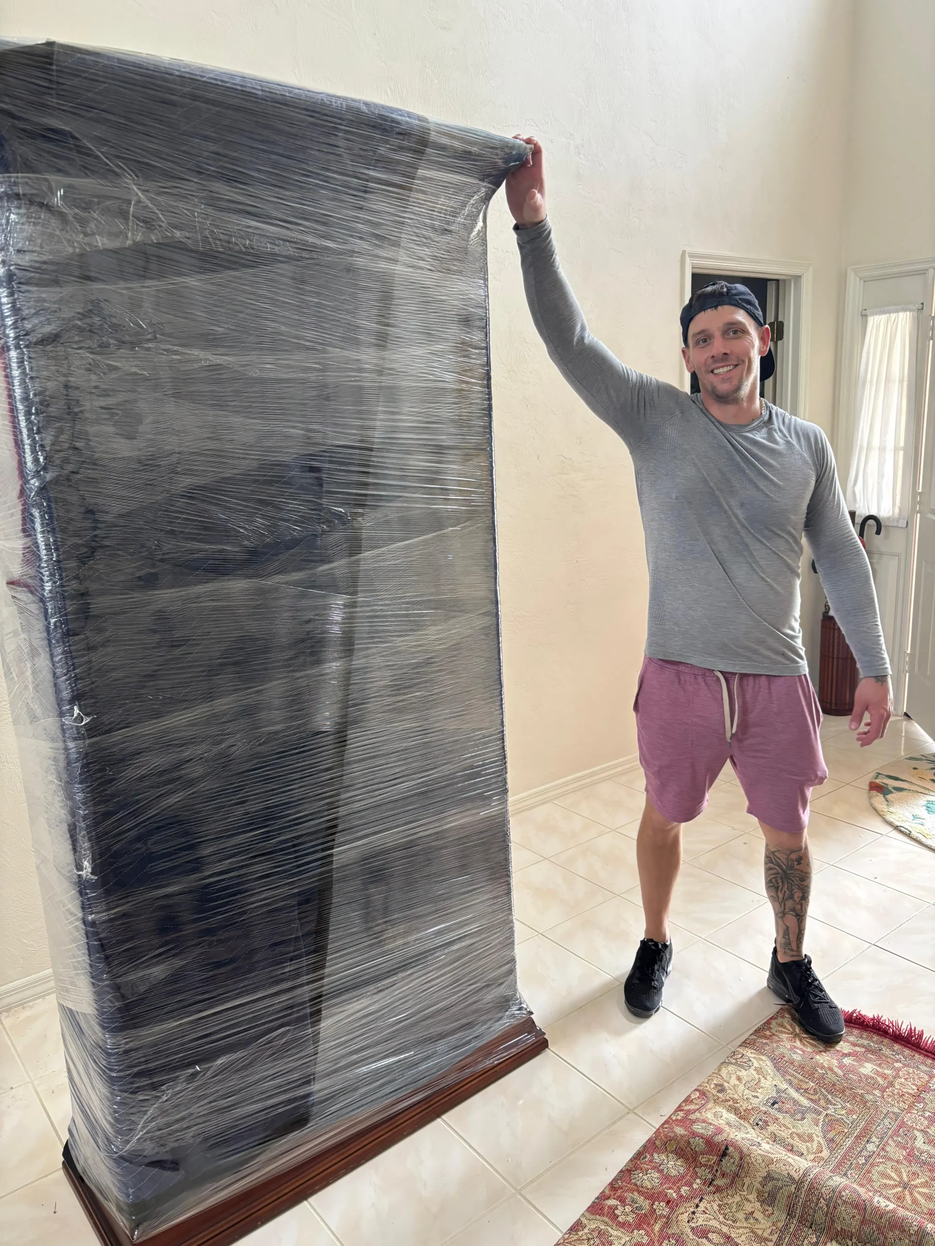 Mover securing furniture with wrap.